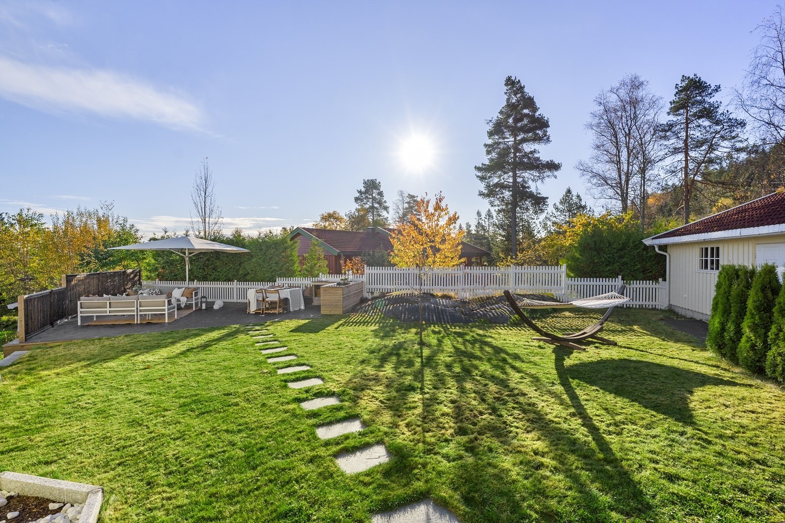 Eiendommen har store, herlige uteplasser og en hage som inviterer til lek og sosiale sammenkomster. Galleribilde