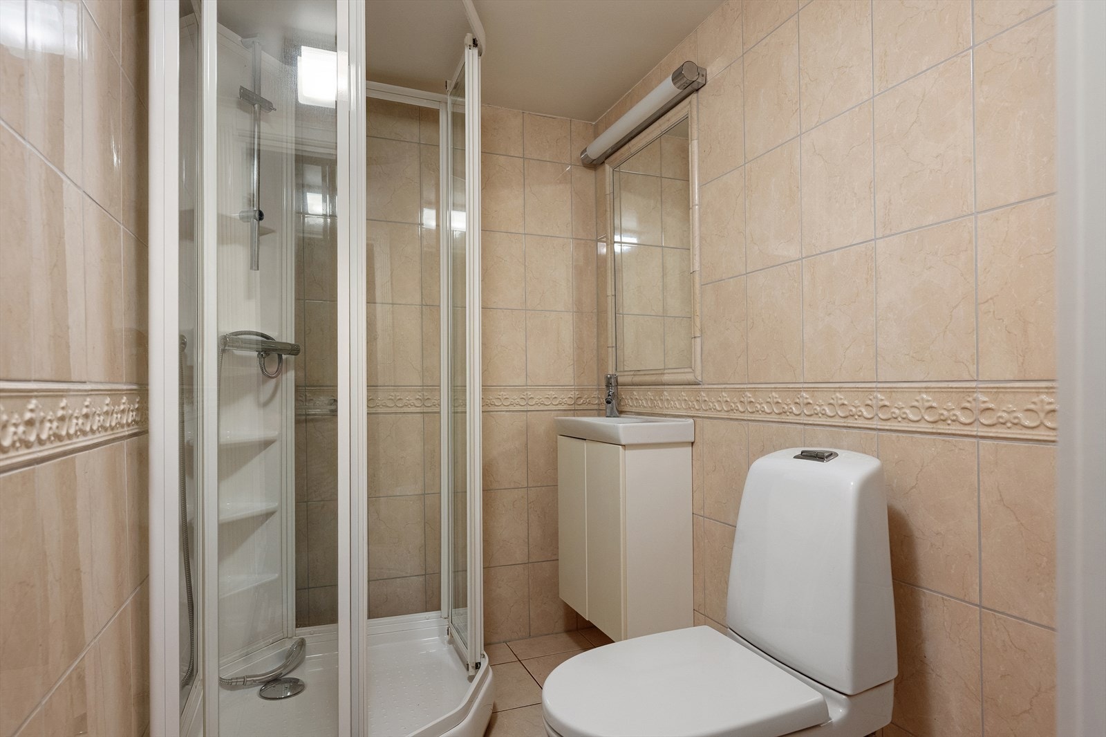 Badet i underetasjen har flislagt gulv med varmekabler, toalett og dusjkabinett. Galleribilde