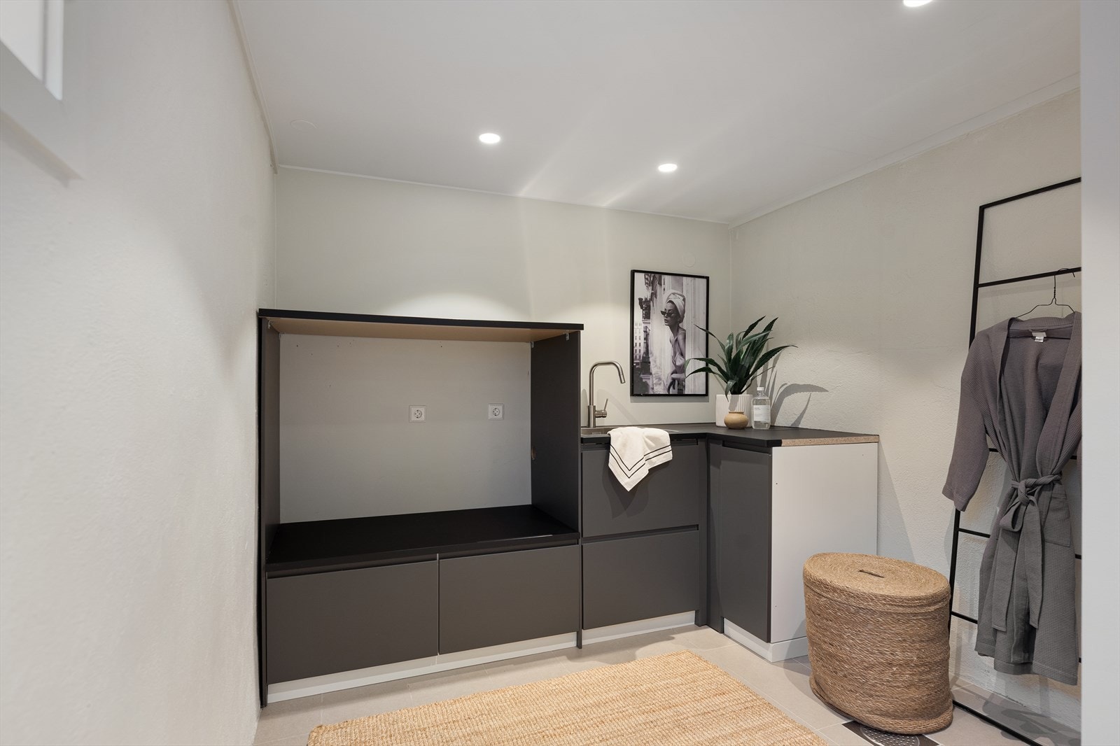 Praktisk vaskerom med innredning, skyllekum og opplegg for vaskemaskin. Galleribilde