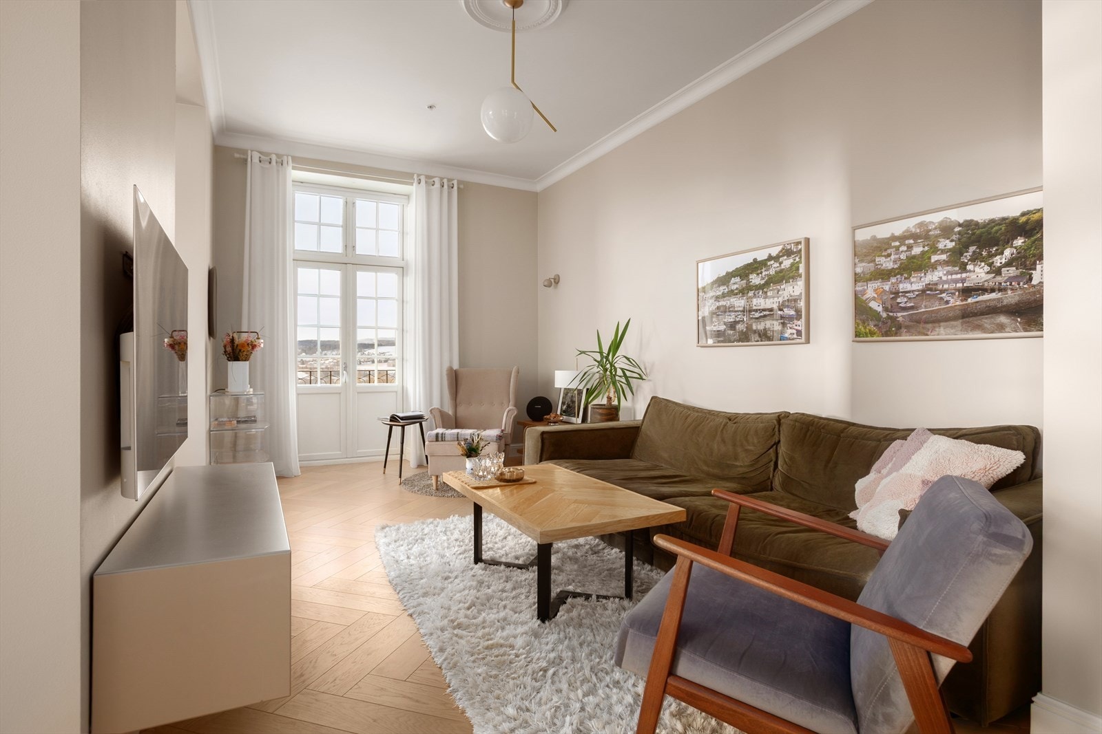 Lyst og klassisk oppholdsrom med fiskebensparkett på gulv, profilert listverk, brede vinduskarmer og god takhøyde på hele 3.10 meter i stuen Galleribilde