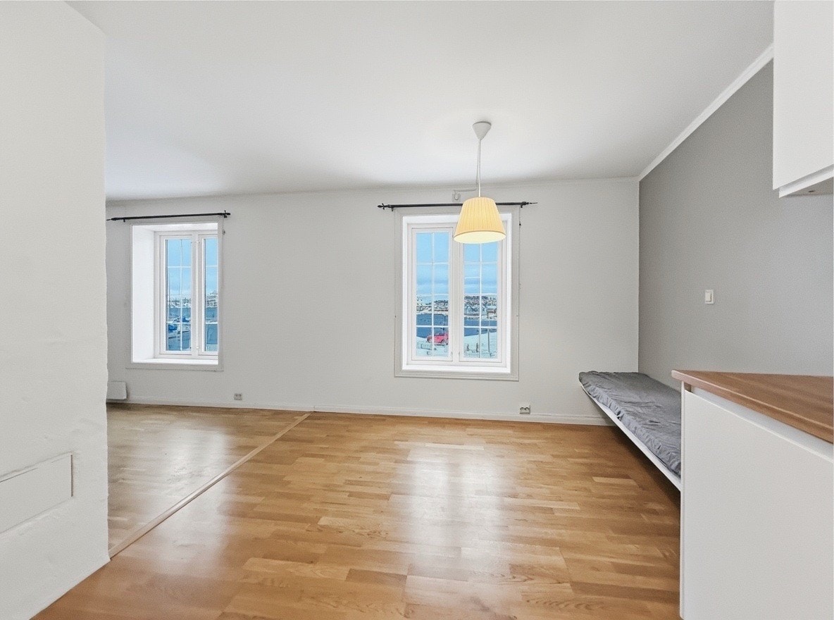 Lys spiseplass ved kjøkkenet med vinduer mot sjøen og innebygd benk Galleribilde