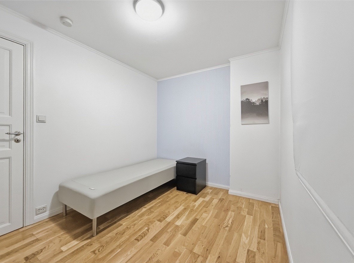 Soverommet har parkett og en rolig atmosfære med plass til enkeltseng og nattbord Galleribilde