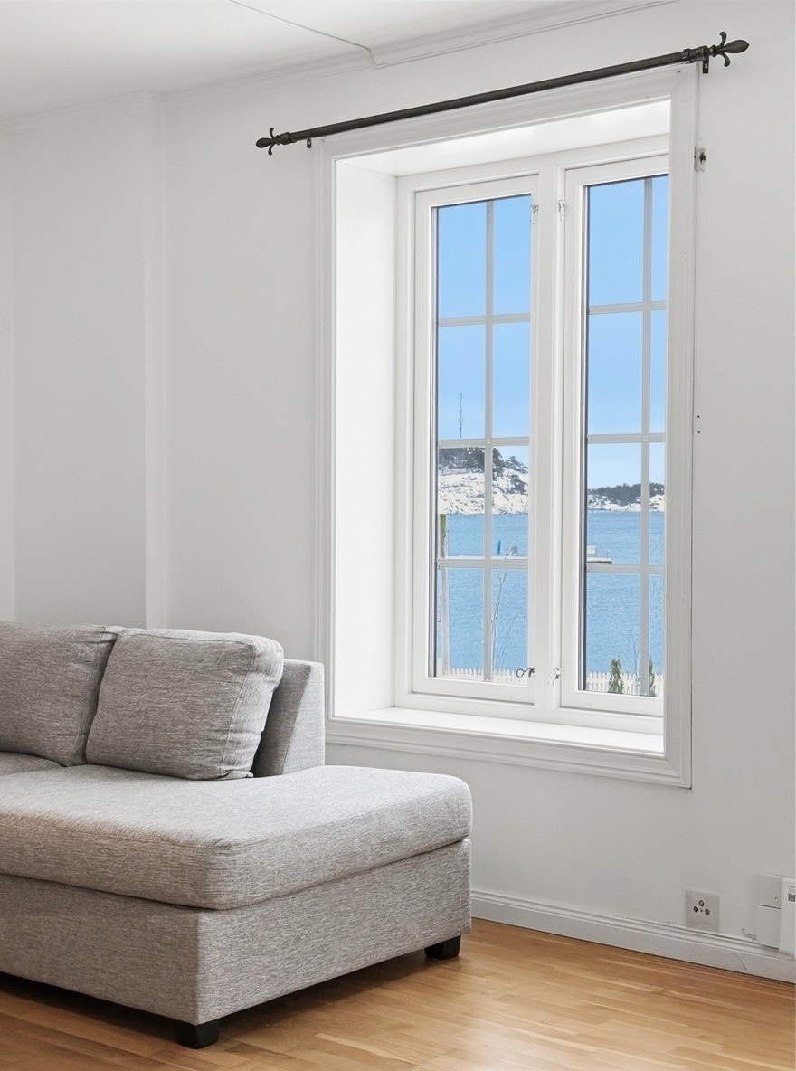 Store vinduer i stuen gir panoramautsikt over sjøen fra sofakroken Galleribilde