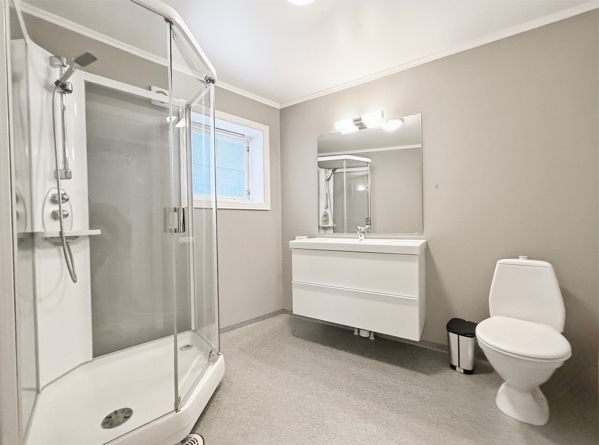 Flislagt bad med dusjkabinett, servant med underskap og toalett Galleribilde