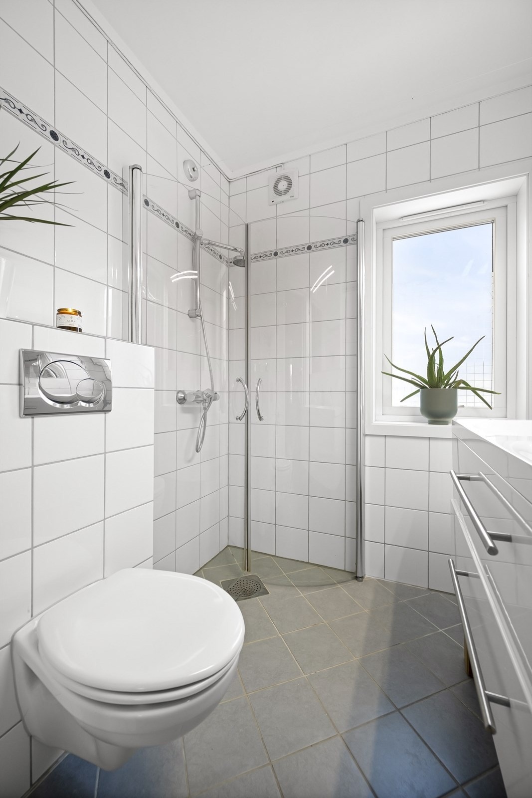 Baderomsinnredningen består av to servanter nedfelt i innredning, vegghengt toalett og speilskap med oppbevaringsplass. Dusjhjørne med innfellbare glassdører. Galleribilde