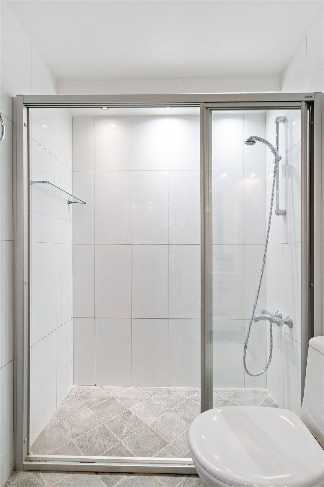 Badet er innredet med servant, skap, toalett, dusj og opplegg for både vaskemaskin og tørketrommel Galleribilde