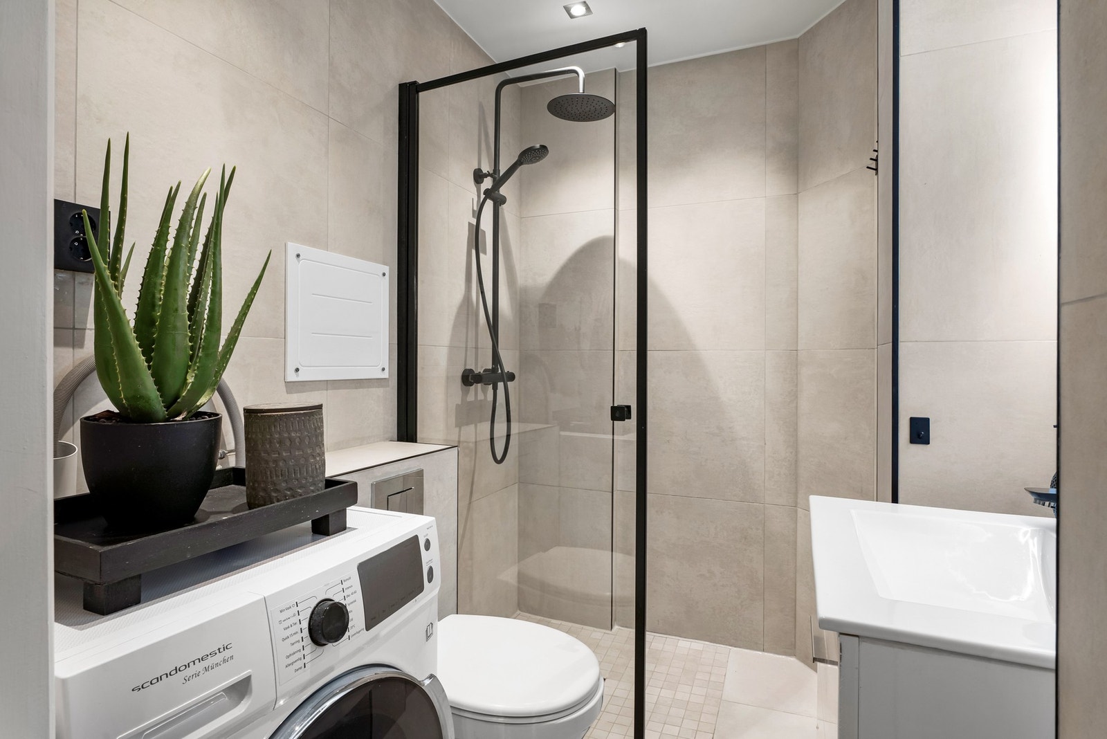 Dusjnisje med regnfallsdusj. Badet har også opplegg for vaskemaskin og varmekabler i gulv. Galleribilde