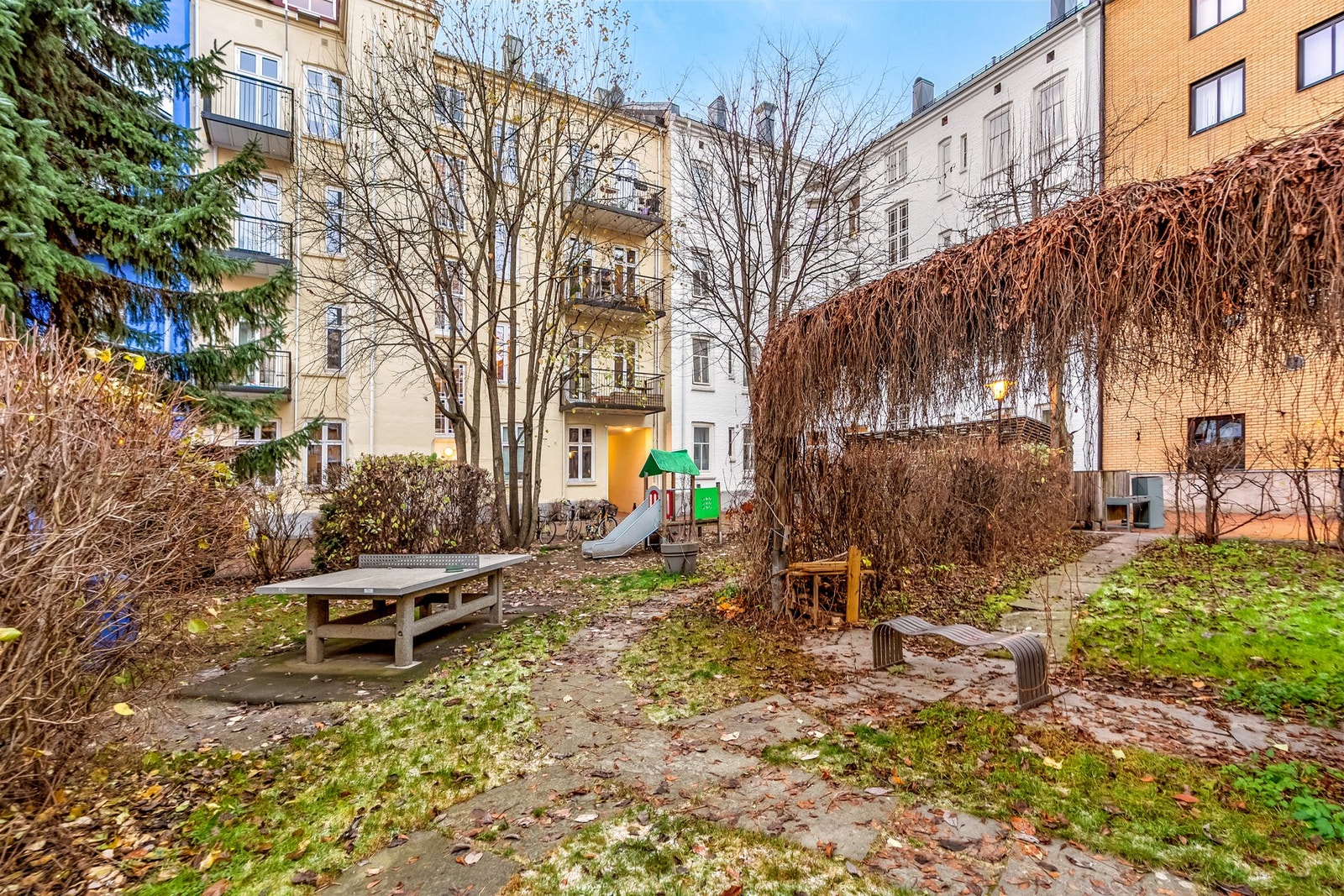 Felles bakgård med sitteplasser og lekeapparater, en trivelig møteplass. Galleribilde