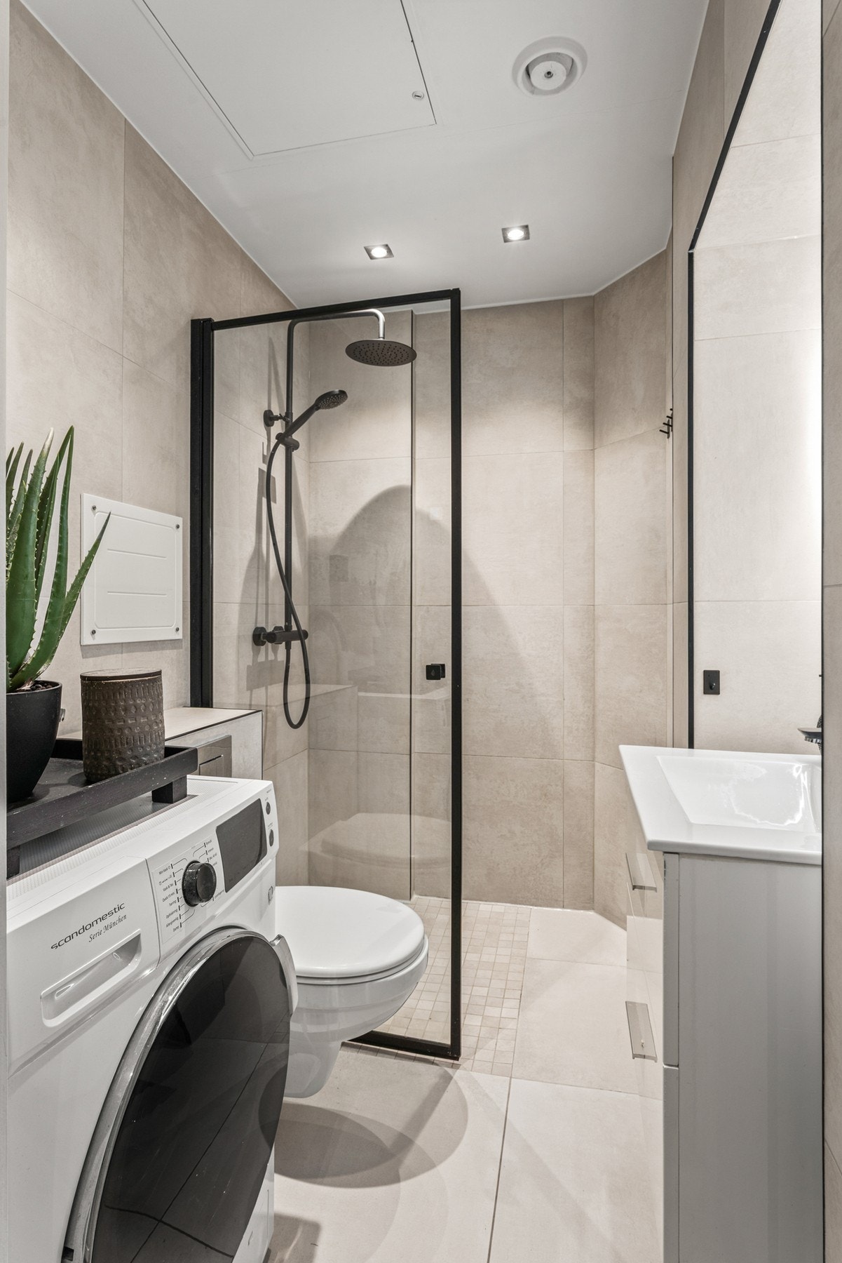 Moderne baderomsinnredning med heldekkende servant over benkeskap med skuffer samt vegghengt toalett. Galleribilde