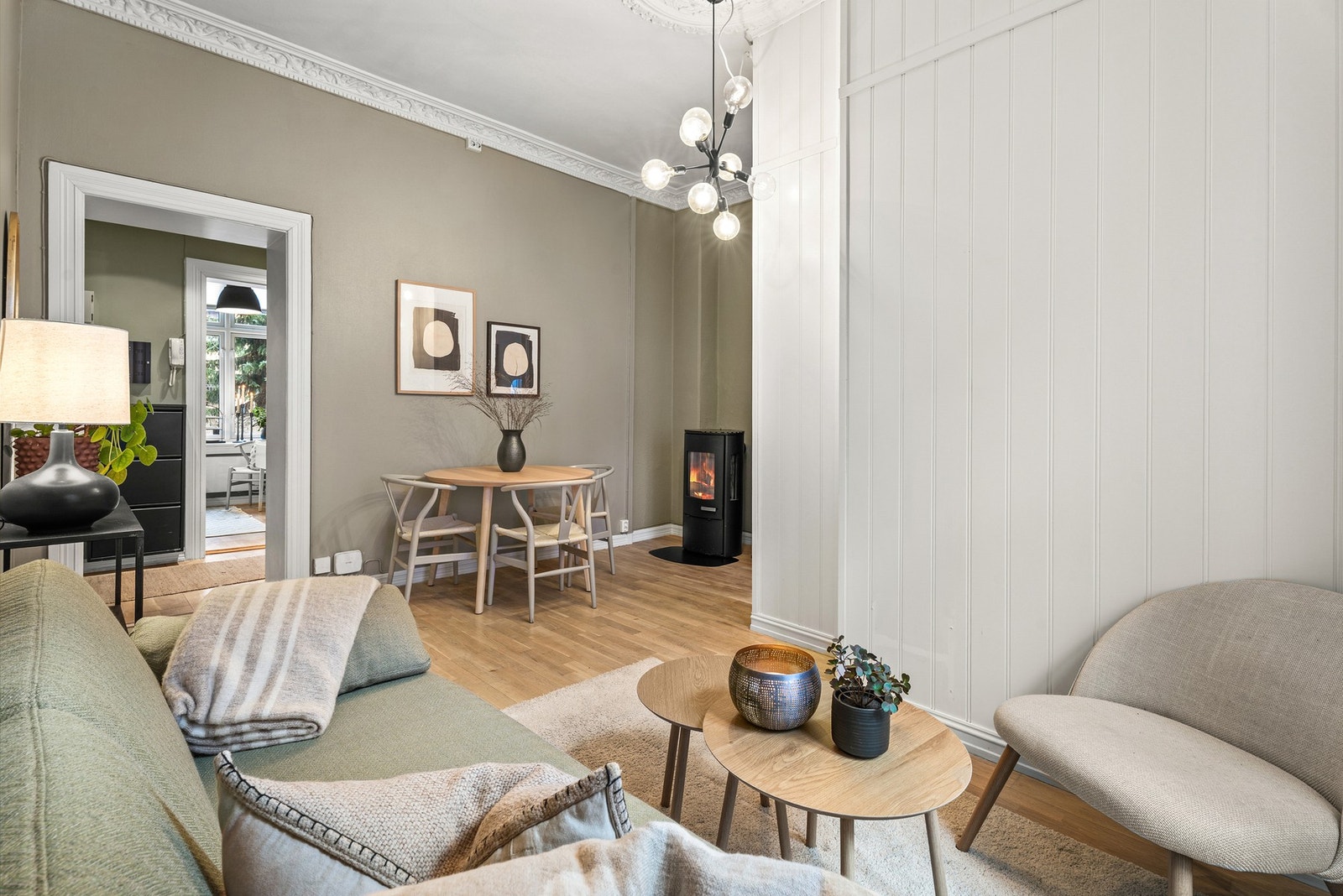 Lys og luftig stue med parkett på gulv, lyse farger på vegg og takhøyde på hele ca. 3,15 meter med stukkatur og rosett. Galleribilde