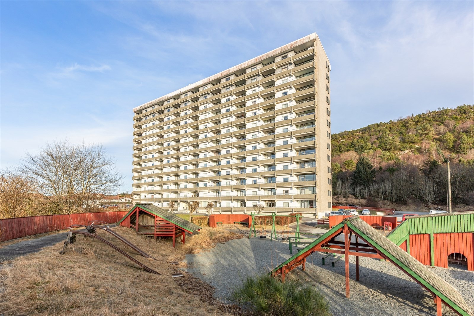 Felles eiet tomt for borettslaget. Meget pent opparbeidet med lekeplass, asfaltert felles parkeringsplass og stor gressplen, busker og trær. Galleribilde