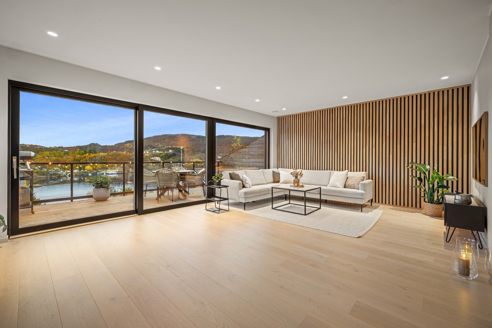 Stor og romslig åpen stue/kjøkkenløsning med store vinduer som slipper inn rikelig med naturlig lys. Galleribilde