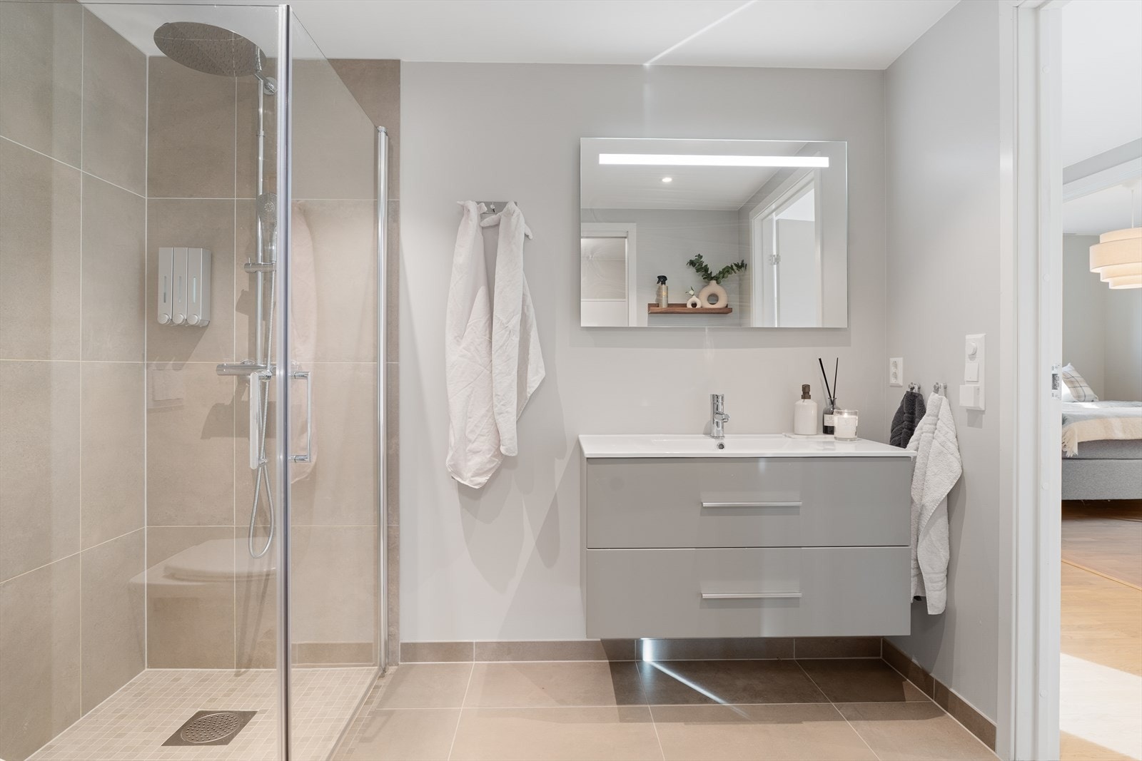 Badet er innredet med flott baderomsinnredning, vegghengt toalett og dusjnisje med glassdører Galleribilde