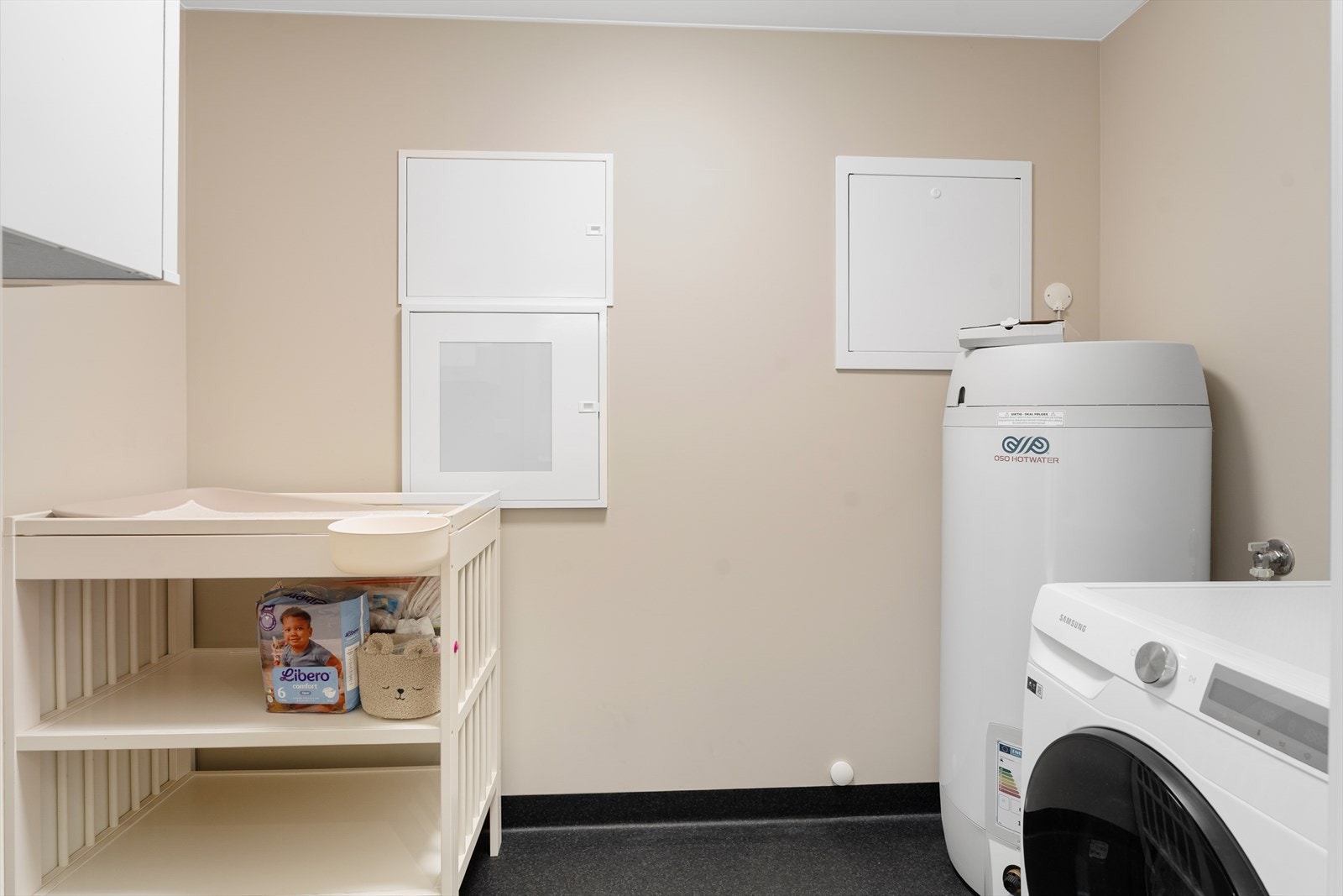 Fra badet er det adkomst til praktisk vaskerom med belegg på gulvet og malte plater på vegger og i himling Galleribilde