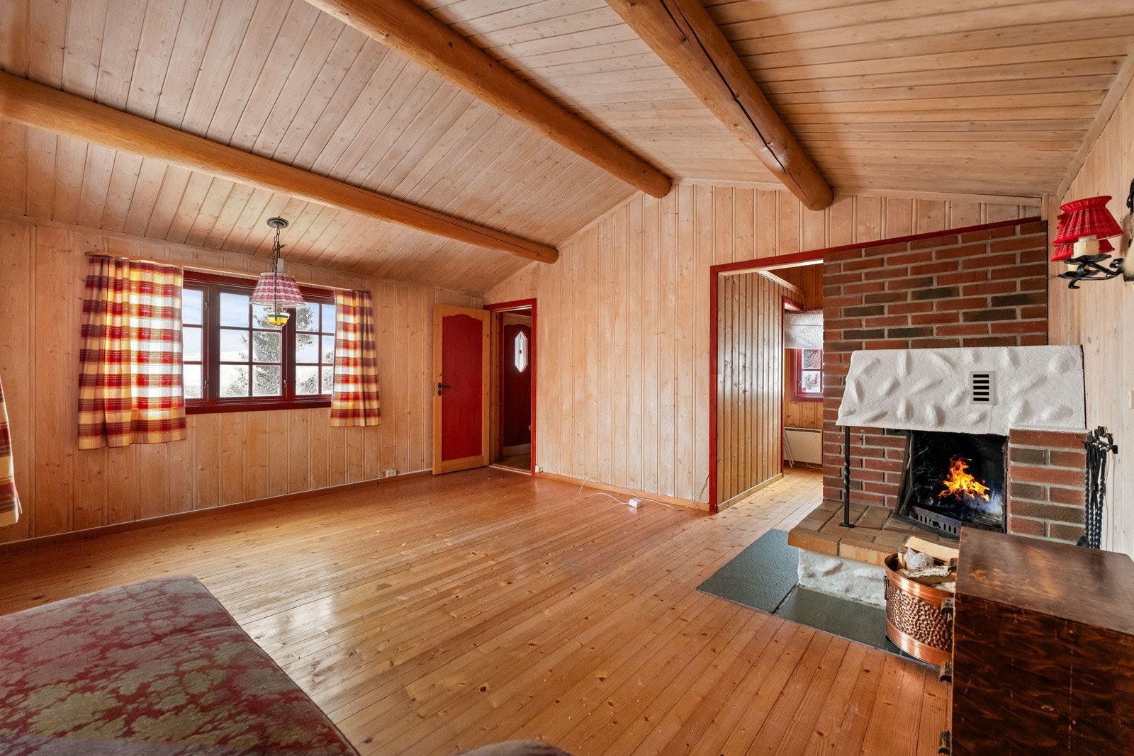 Store vindusflater slipper inn rikelig med lys, og peisen skaper god varme og hygge på kalde dager. Galleribilde