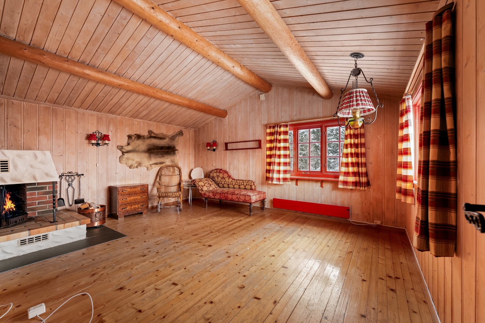 Luftig og åpen stue med flott takhøyde og synlige tømmerbjelker. Galleribilde