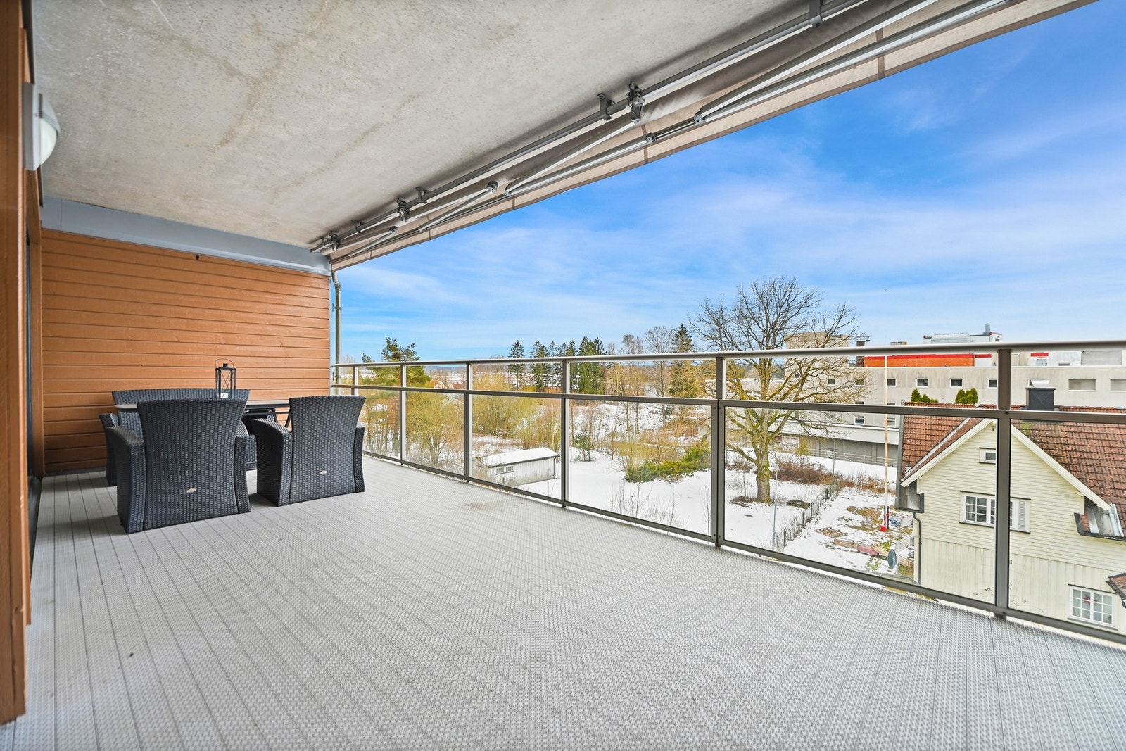 Overbygget balkong med glassrekkverk og utsikt mot nærområdet. Galleribilde