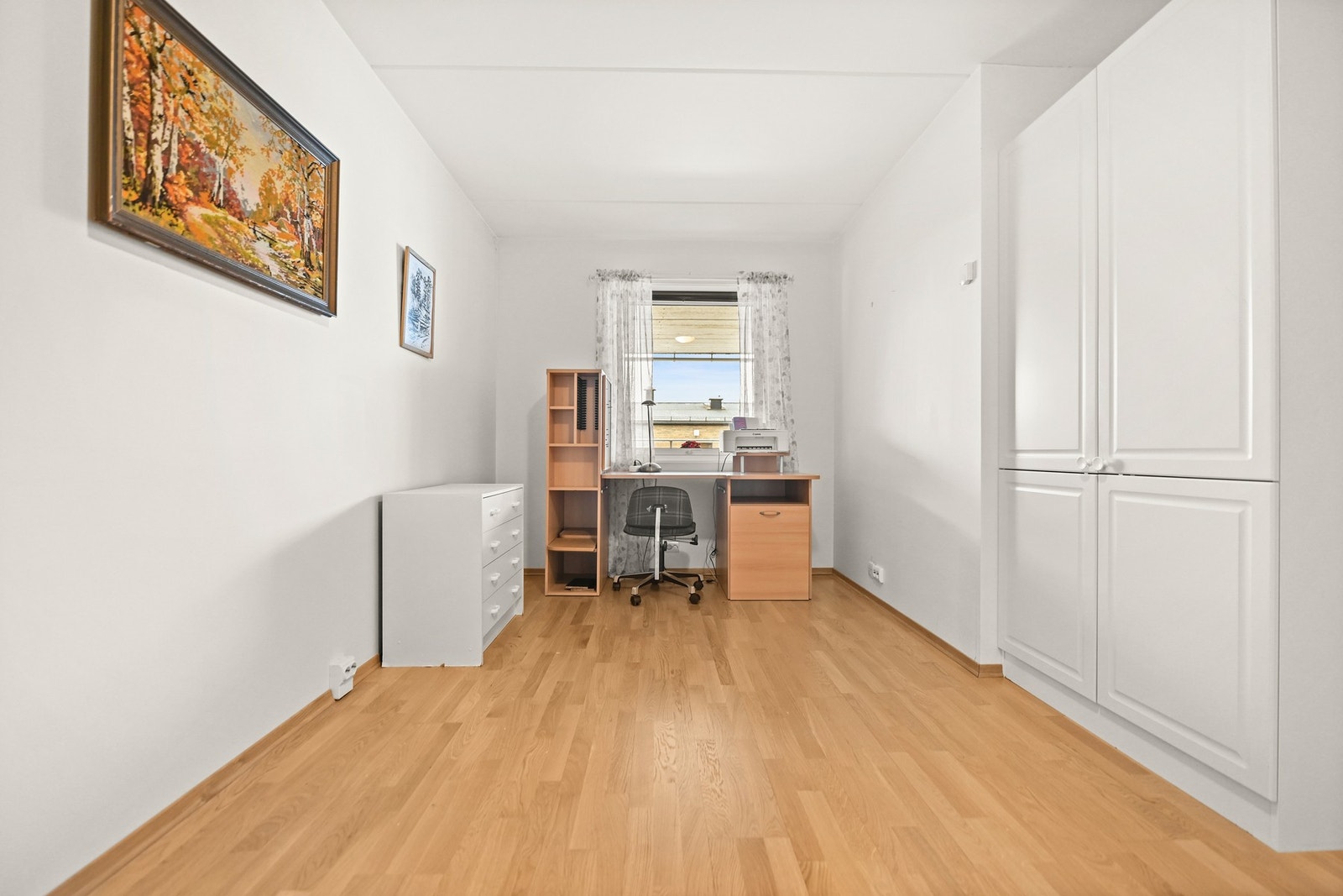 Lyst og luftig rom med vindu som gir godt naturlig lys. Rommet har parkettgulv og hvitmalte vegger. Galleribilde