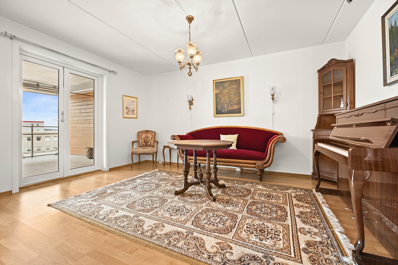 Stuen har lysmalte vegger, parkettgulv og utgang til en romslig balkong med utsikt. Galleribilde