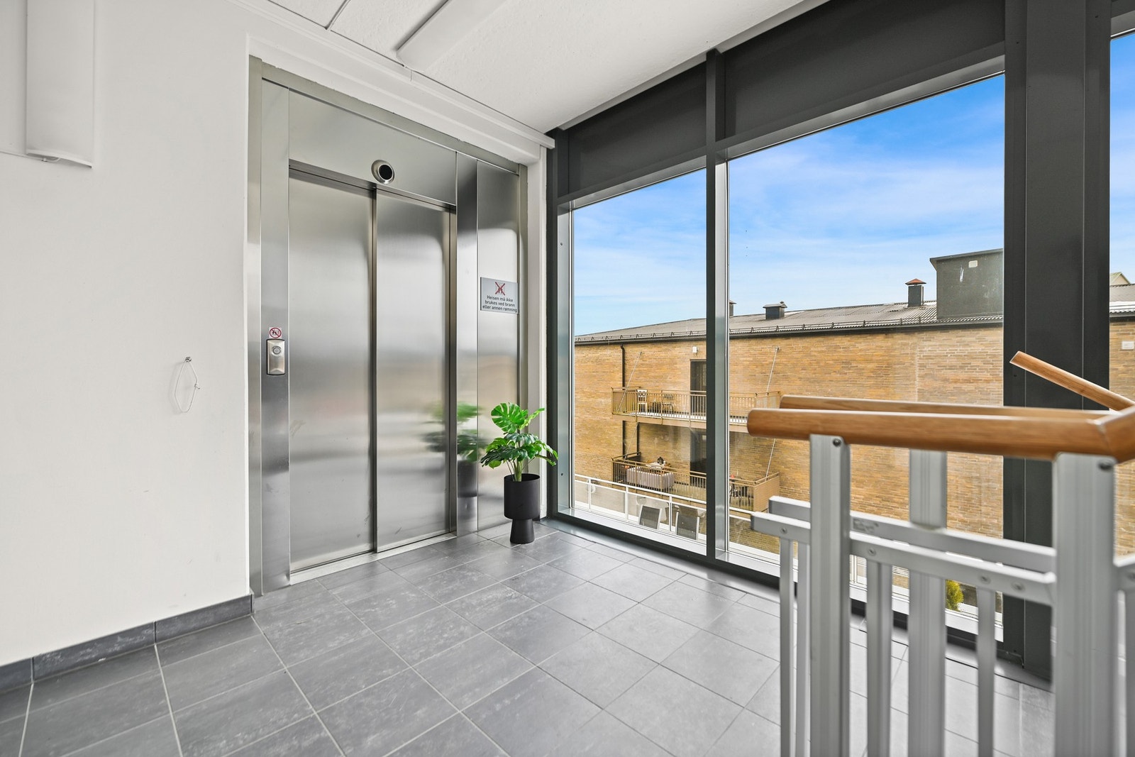 Heisområde med store vinduer som gir godt lysinnslipp. Flislagt gulv og moderne heis. Galleribilde