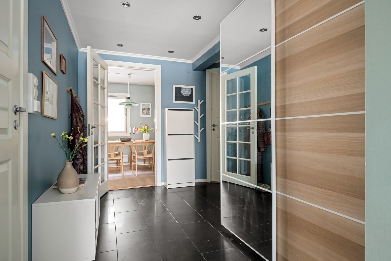 Boligen ønskes velkommen gjennom en romslig entré med flislagt gulv og varmekabler. Entréen har god plass til oppbevaring og gir et ryddig og praktisk førsteinntrykk. Galleribilde