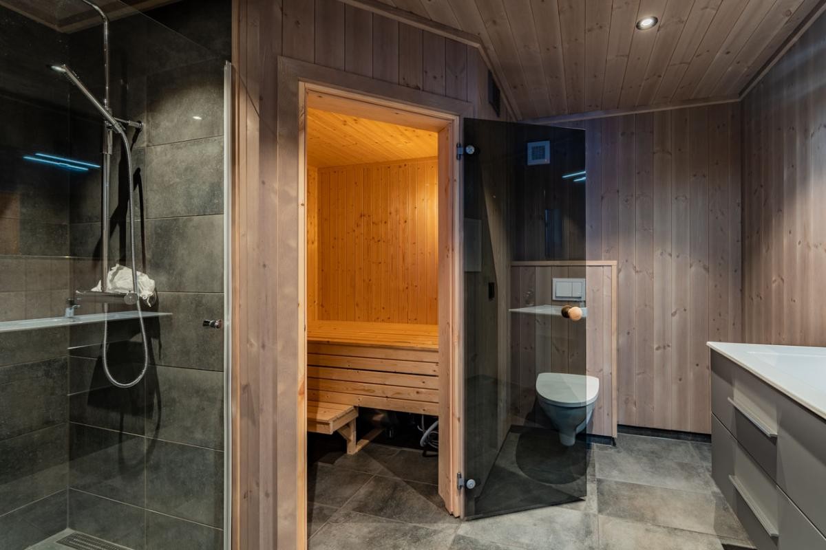 Bad med 30x60 fliser, unidrain slukrenne, vegghengt toalett og badstue. Interiørbilder fra en lik hytte. Farger og produkter kan avvike. Galleribilde