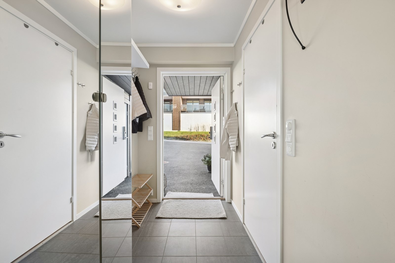 Man ønskes velkommen i en flislagt entré med plass til å henge fra seg yttertøy. Galleribilde