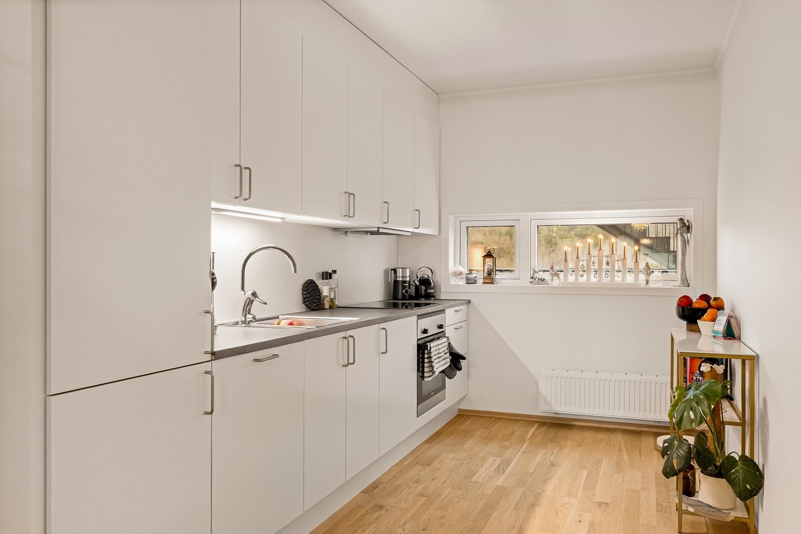 Det tilknyttede kjøkkenet er funksjonelt og tidløst, med hvite fronter og integrerte hvitevarer. Galleribilde