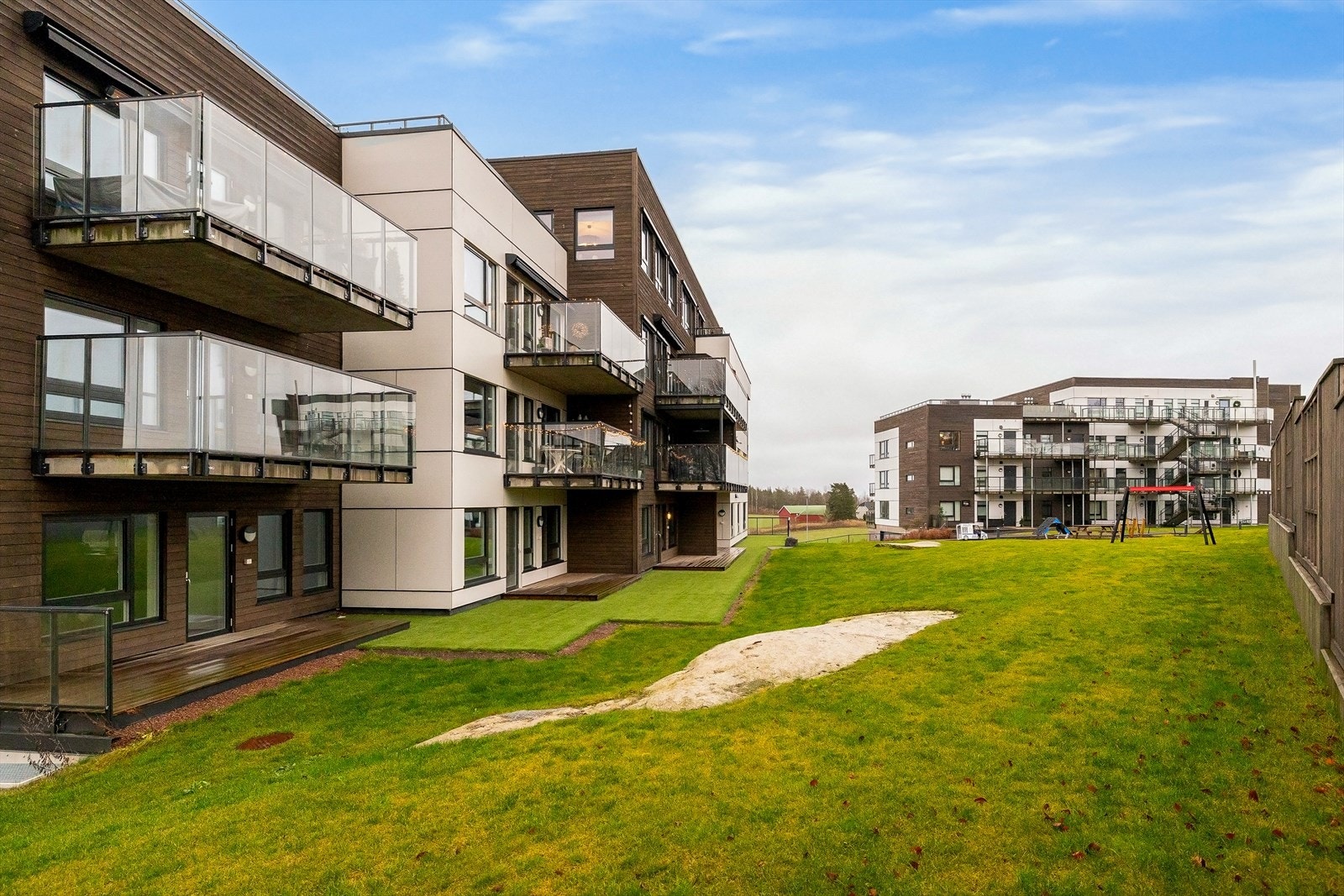 Moderne leilighetskompleks med en attraktiv beliggenhet i et rolig og familievennlig område. Bygget har en stilren fasade med store balkonger som gir flott utsikt over omgivelsene. Galleribilde