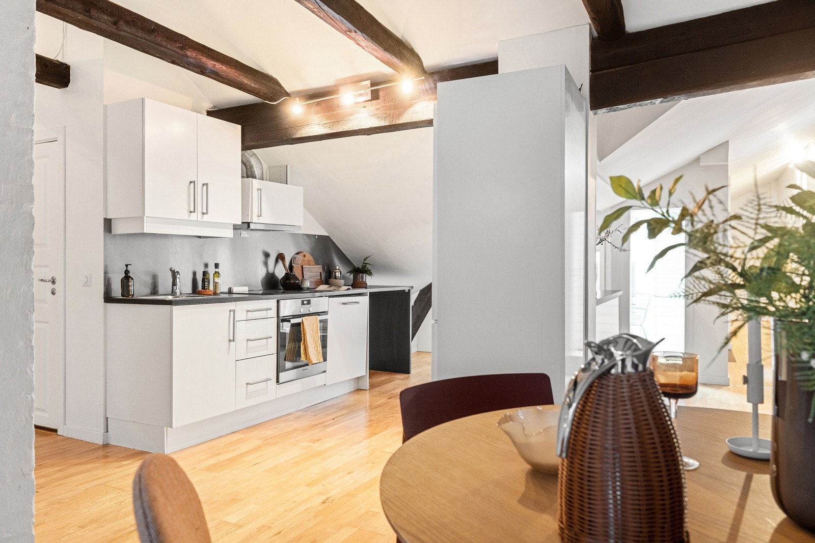 HTH-kjøkkeninnredning med glatte hvite fronter og mørk laminatbenkeplate. Galleribilde