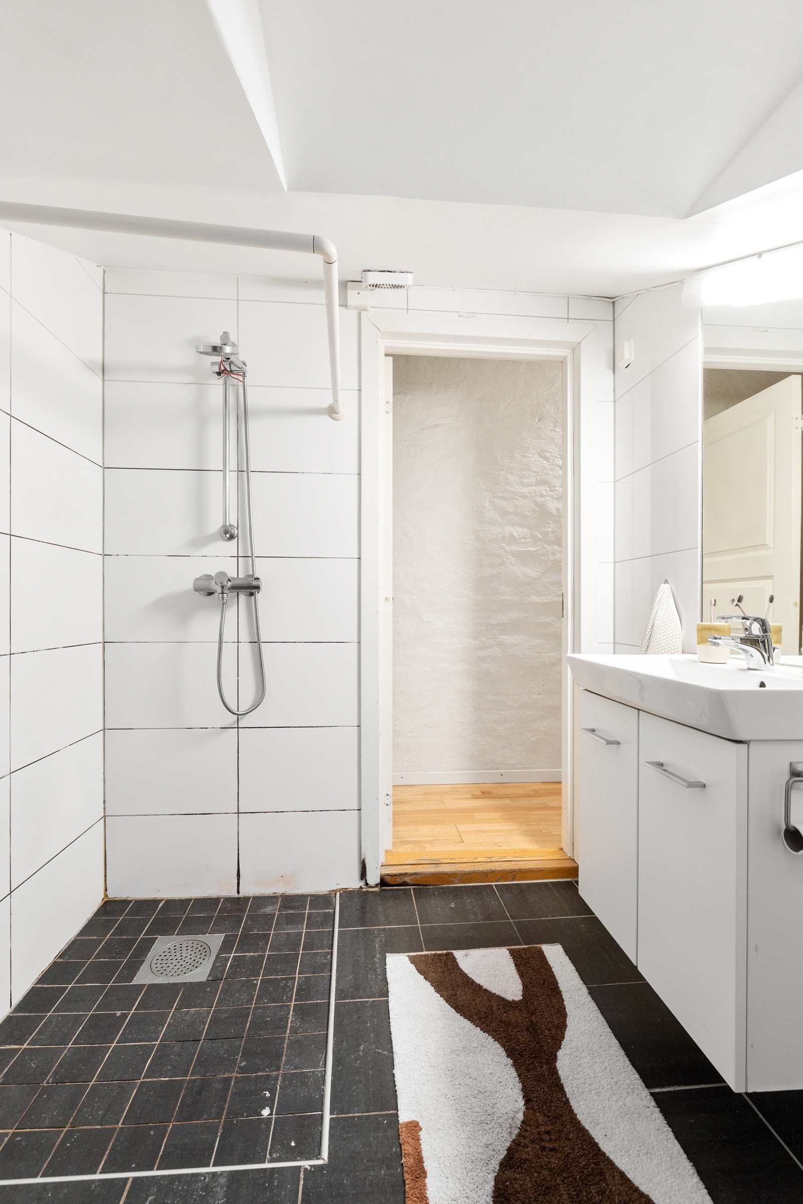 Badet er utstyr med opplegg for vaskemaskin, servantskap, veggmontert wc og dusjhjørne. Galleribilde