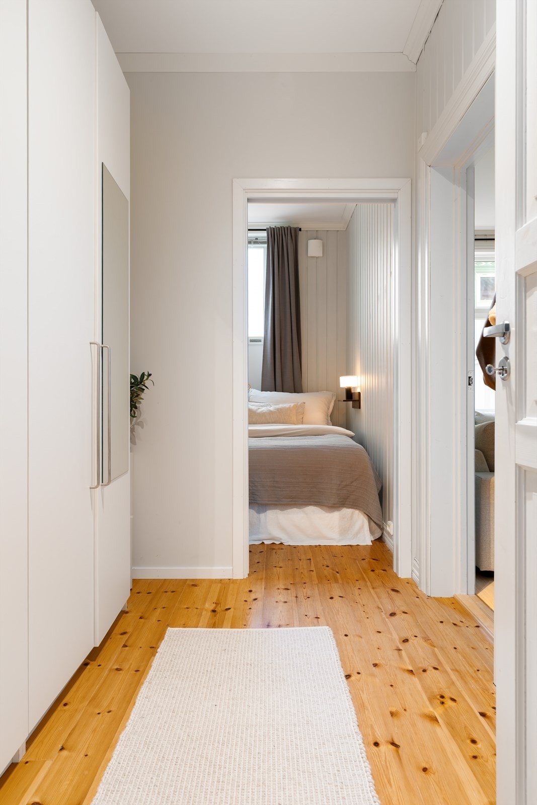 Romslig gang/garderoberom mellom soverom og bad med heltre gulv. Galleribilde