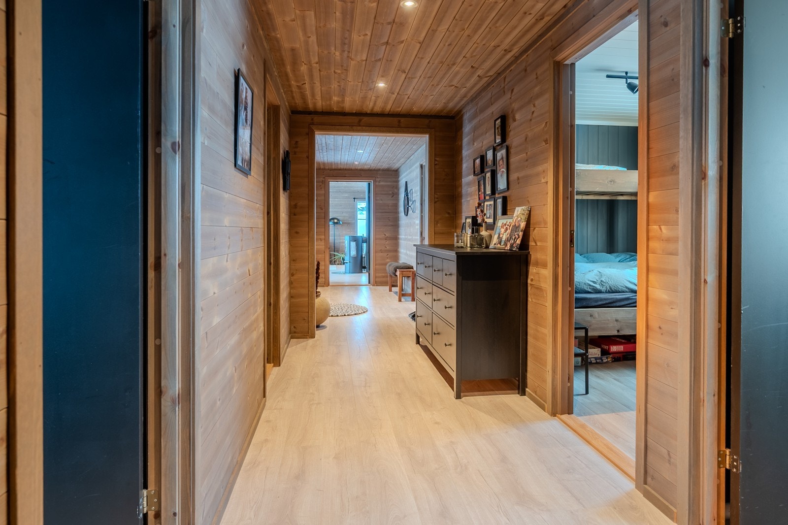 Gang med slitesterkt laminatgulv, beiset panel og spotter i himling Galleribilde