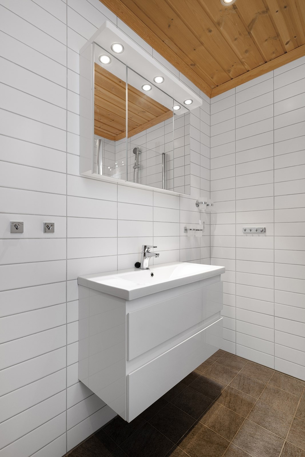 Baderomsinnredningen har glatte fronter og heldekkende servant. Galleribilde