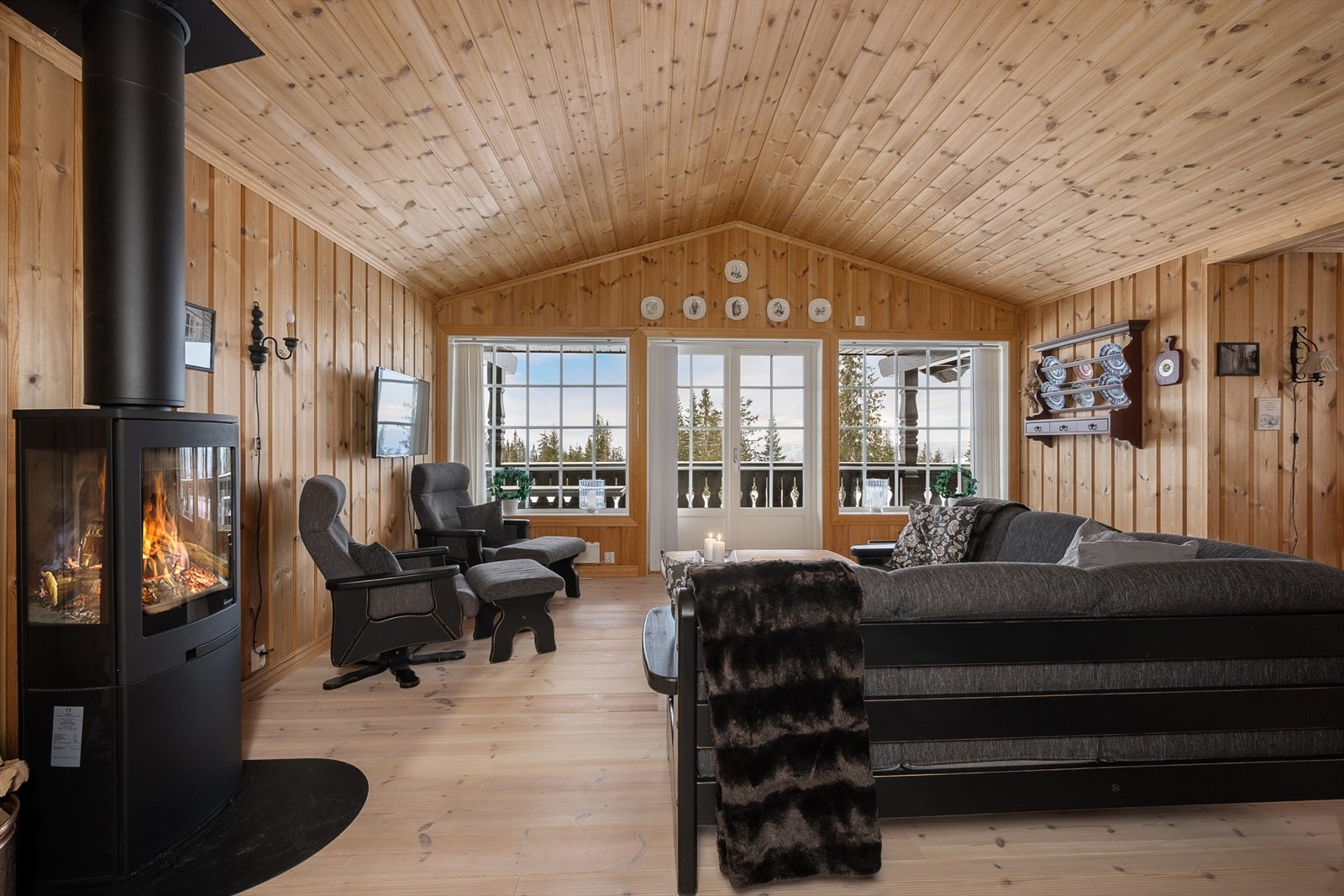 Stuen er hyttas samlingspunkt, med skråhimling som skaper en luftig atmosfære. Galleribilde