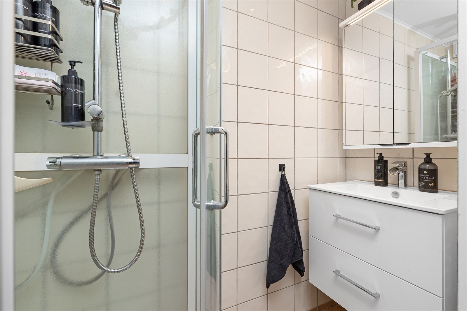 Badet med adkomst fra soverommet består av speilskap, seksjon med servant og dusjkabinett. Galleribilde