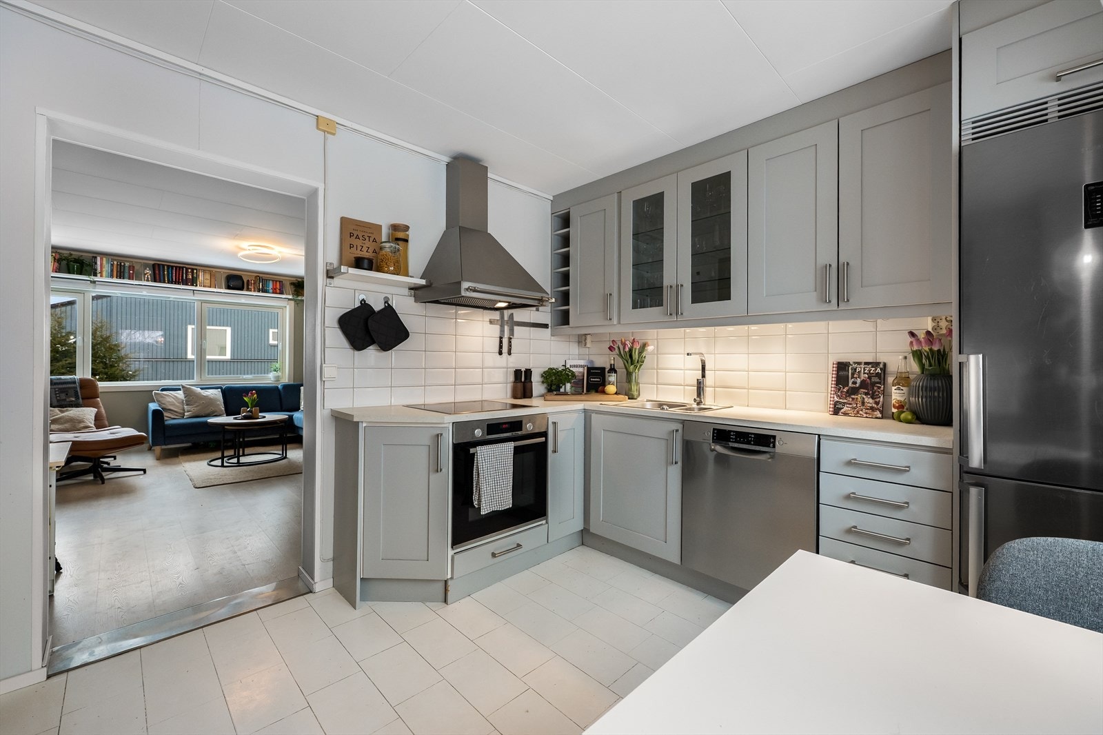 Praktisk kjøkkenoppsett med takhøye skap og delintegrerte hvitevarer. Galleribilde