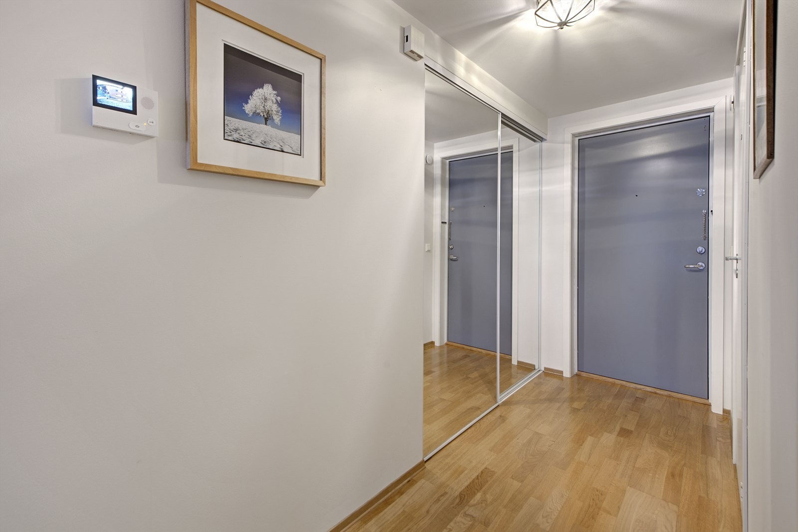 Innbydende entré med skyvedørsgarderobe for praktisk oppbevaring. Galleribilde