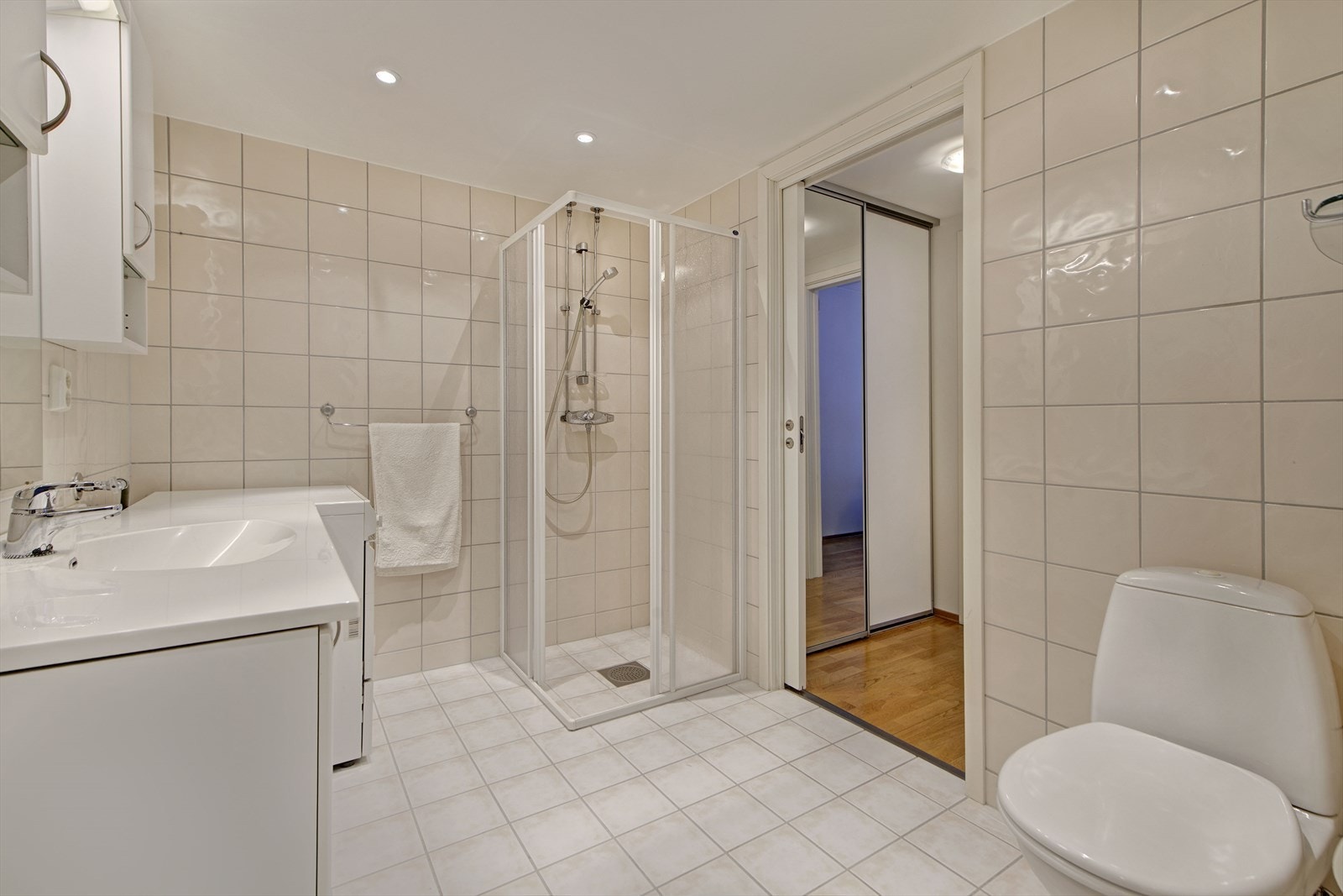 Helfliset bad med dusjhjørne og opplegg for vaskemaskin. Galleribilde