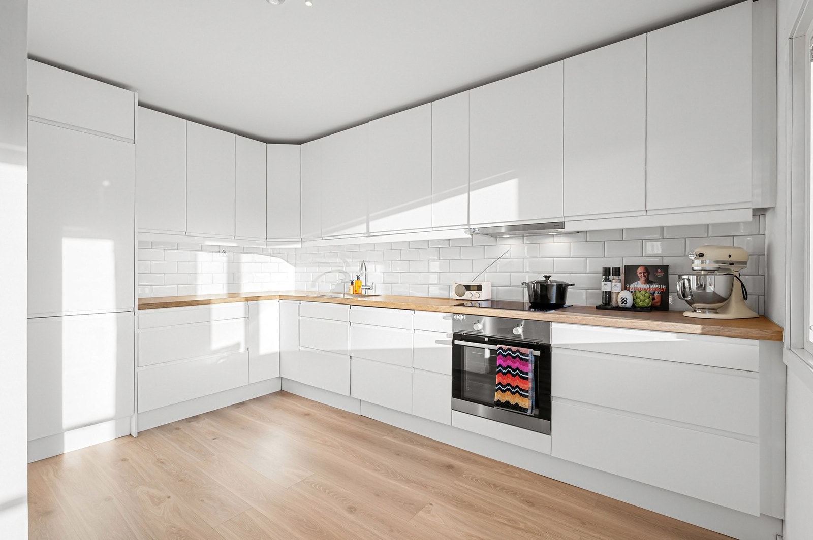 Moderne kjøkken, med hvit, stilren innredning og integrerte hvitevarer. Galleribilde