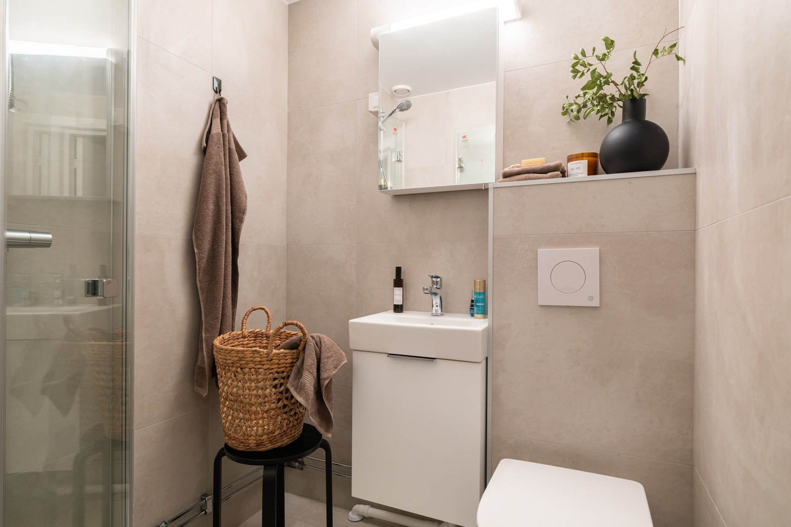 Leiligheten har et moderne baderom som ble oppgradert med flis-på-flis og nye baderomsmøbler i 2025. Baderommet har flotte fliser på gulv og vegger, elektriske varmekabler og mekanisk avtrekk. Galleribilde