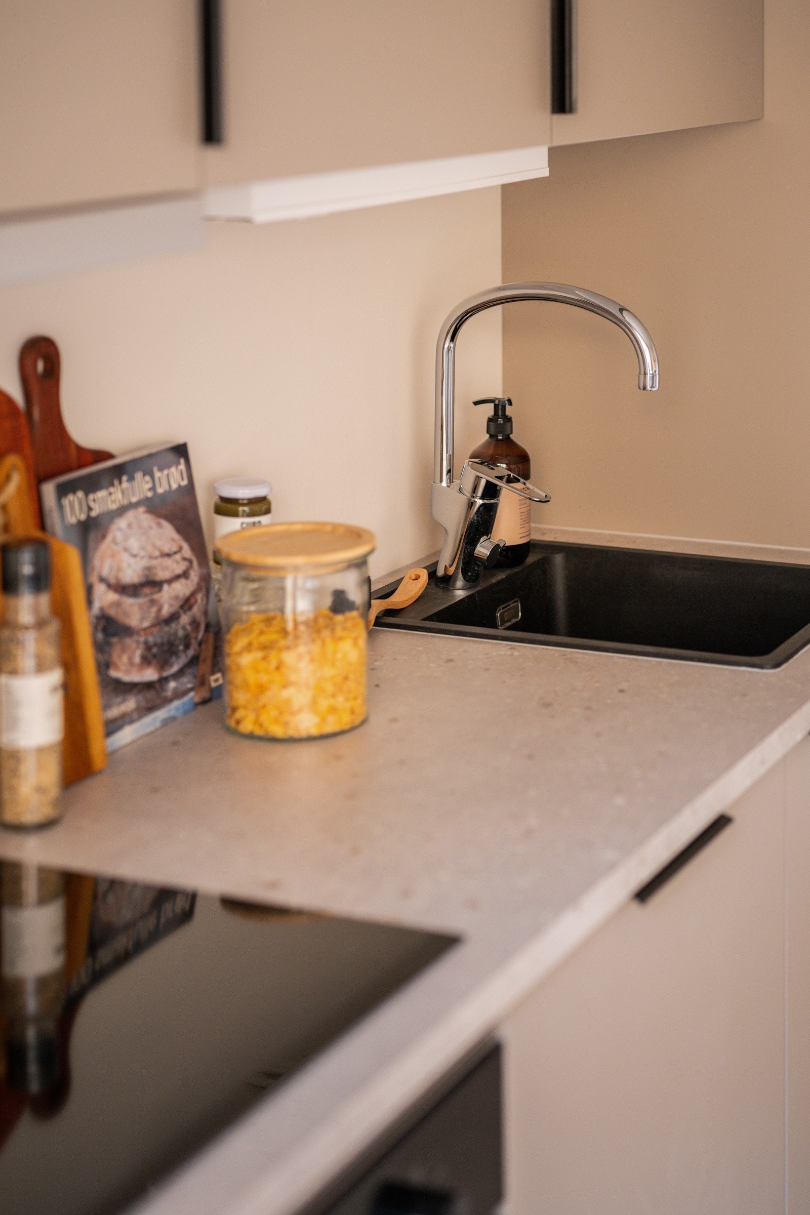 Både fint og praktisk med flotte fliser i benkeryggen og belysning under overskap. Galleribilde