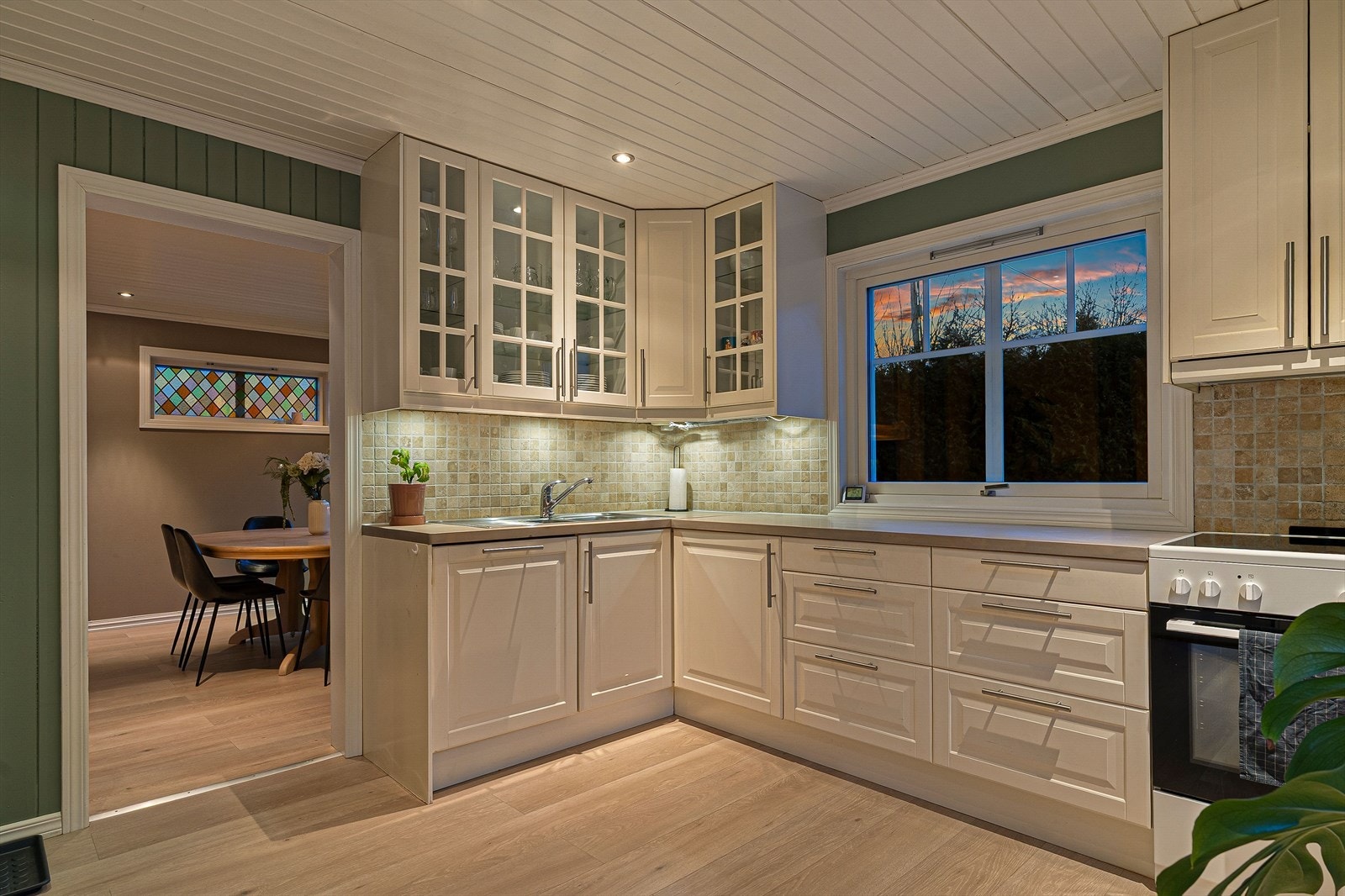 Kjøkkenet ligger i et eget rom med klassisk innredning i lyse fronter og godt med skap- og benkeplass. Galleribilde