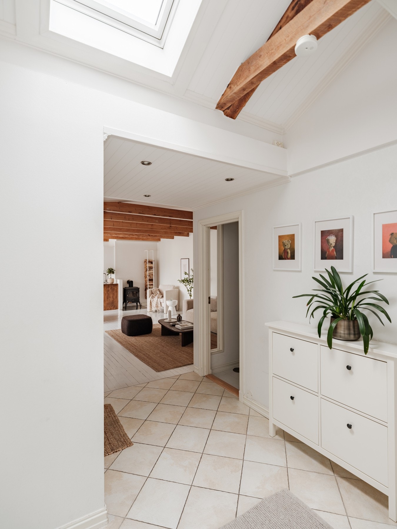 Stor og romslig entré/gang med flislagt gulv med gulvvarme og elektrisk takvindu i himling som gir gode lysforhold. Galleribilde