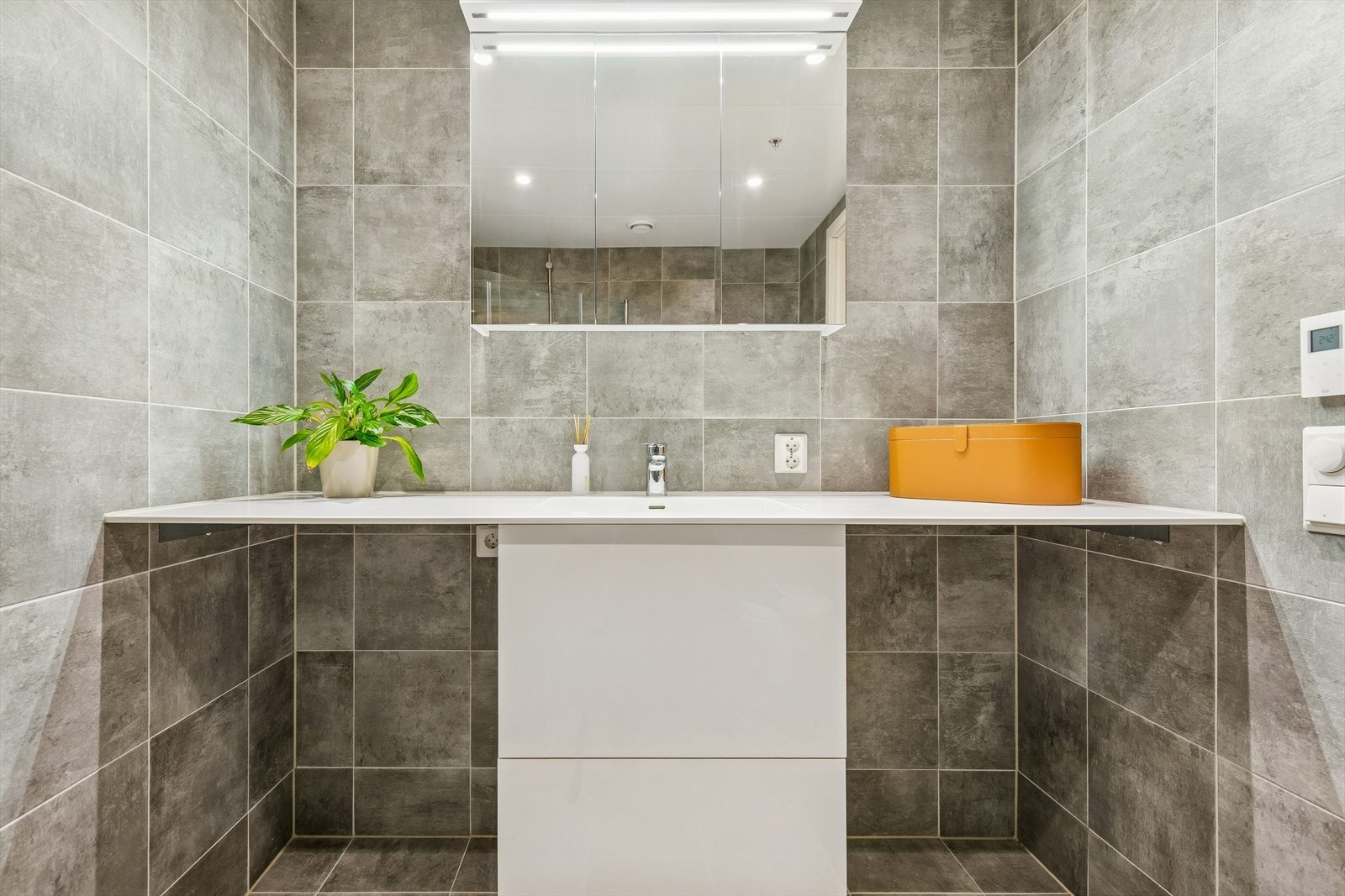 Benk med heldekkende Corian benkeplate m/integrert vask, og med plass til vaskemaskin og tørketrommel. Galleribilde