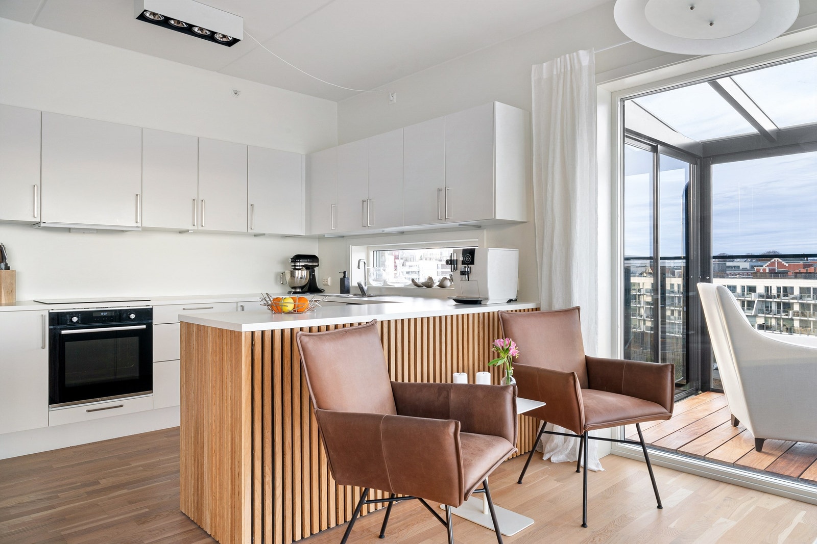 Kjøkken i hvit utførelse med rikelig med skap- og benkeplass. Galleribilde