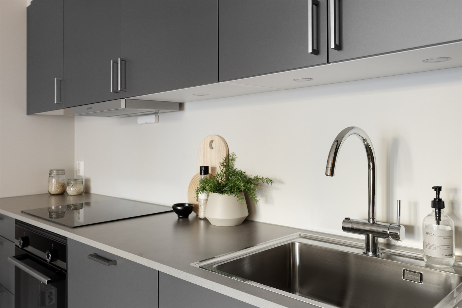 Laminert benkeplate i 20 mm tykkelse. Det er LED-downlights med dimmer og stikkontakt i underkant overskap. Galleribilde