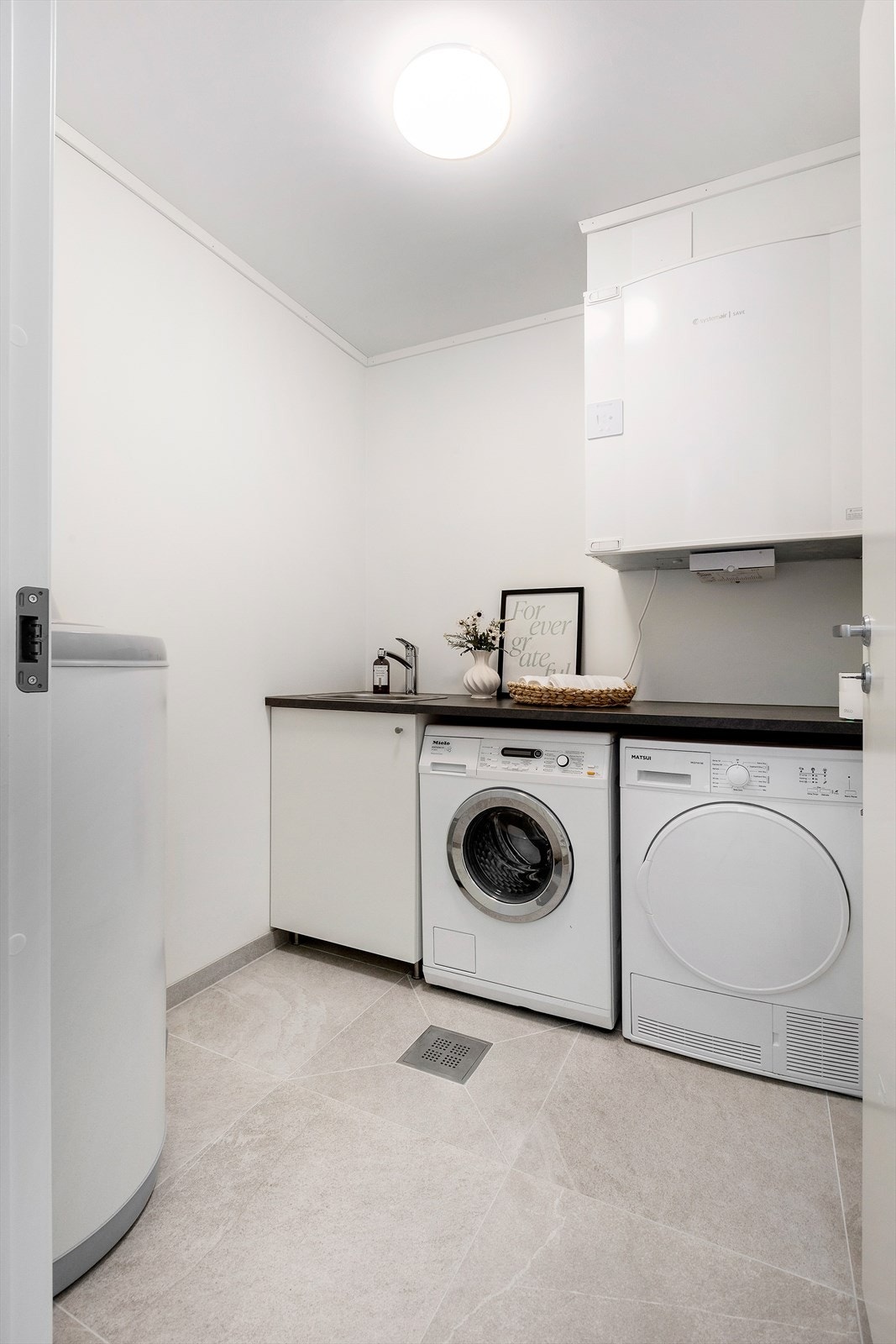 Vaskerommet er praktisk utstyrt med innredning, opplegg for vaskemaskin, varmtvannsbereder, sikringsskap og ventilasjonsaggregat. Galleribilde