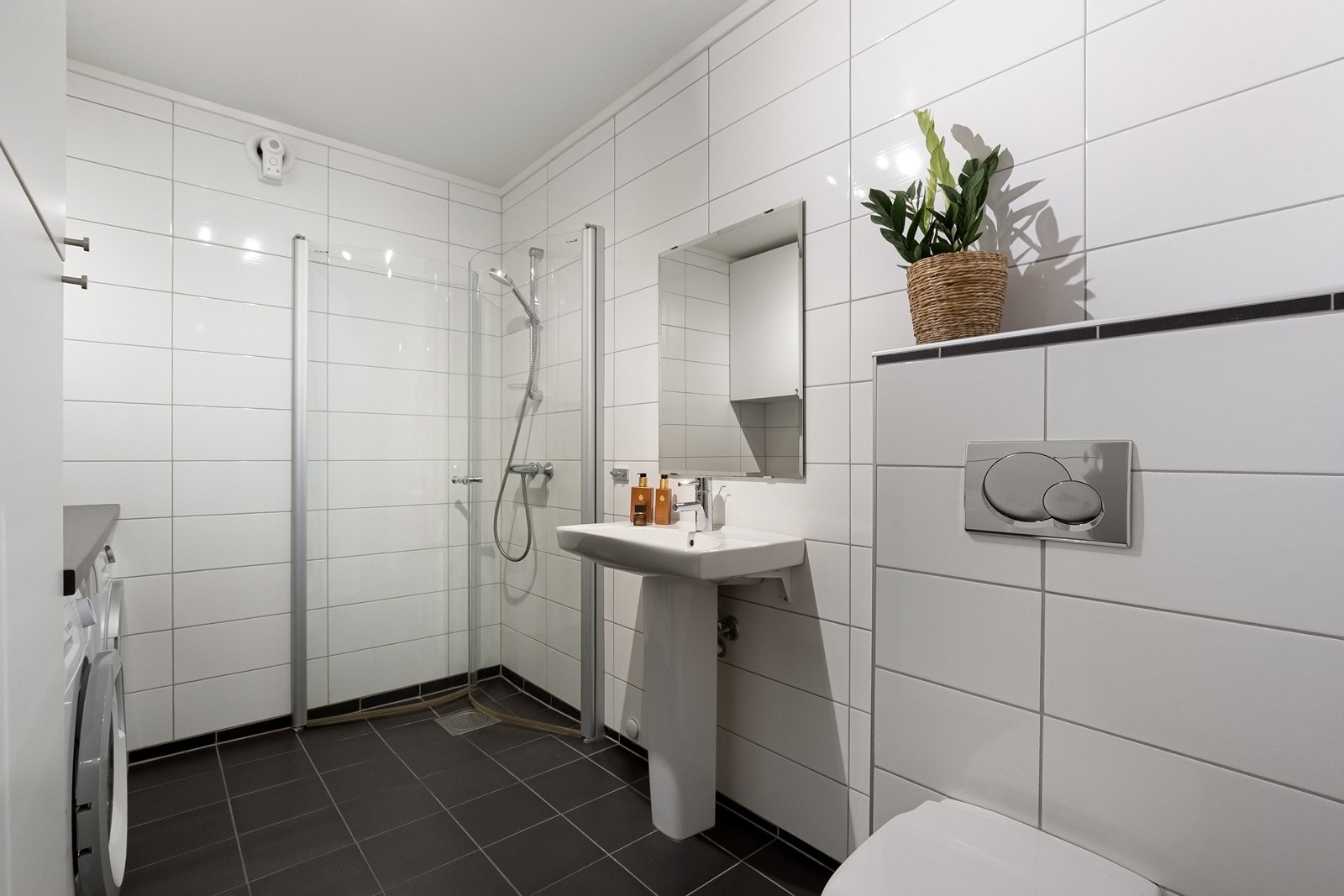 Bad og vaskerom i kjelleretasjen. Skap og benk, samt plass til vaskemaskin og tørketrommel . Galleribilde