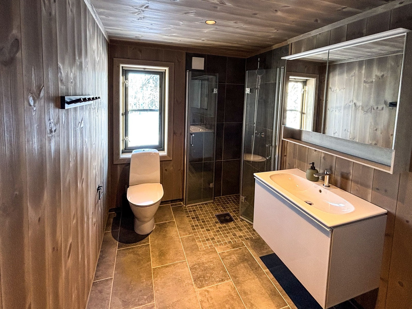 Moderne baderomutsyr, og foldedører i dusjen for mest mulig plassutnyttelse Galleribilde